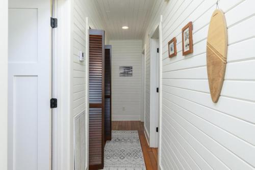 a hallway of a home with white walls and a door at Longboard House in Tybee Island