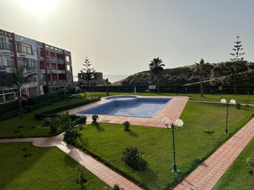 uma imagem de uma piscina num quintal em La Siesta Bel appartement bord de mer avec piscine em Mohammedia