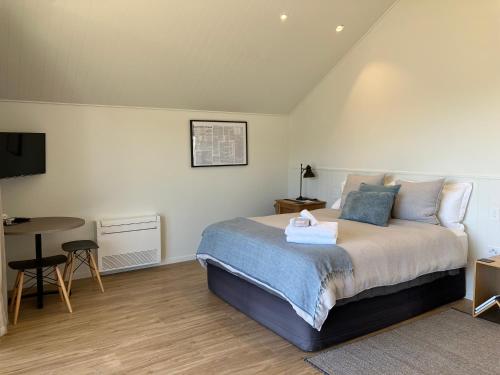 a bedroom with a bed and a table and a desk at The Quarters Unit 2 - Lake Tekapo in Lake Tekapo