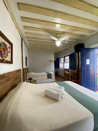 a bedroom with two beds with towels on them at Canto do Bichinho in Prados