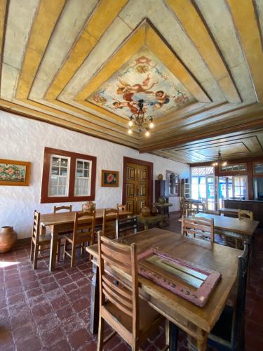 une salle à manger avec une table et des chaises et un plafond dans l'établissement Canto do Bichinho, à Prados