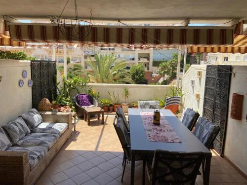 eine Terrasse mit einem Sofa, einem Tisch und Stühlen in der Unterkunft Real Torrequebrada in Benalmádena