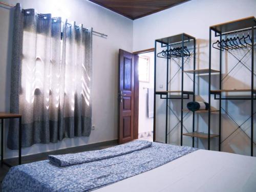 a bedroom with a bed and racks of clothes at Mado Coliving - Studio Appart, Chambre coin cuisine, Chambre in Douala