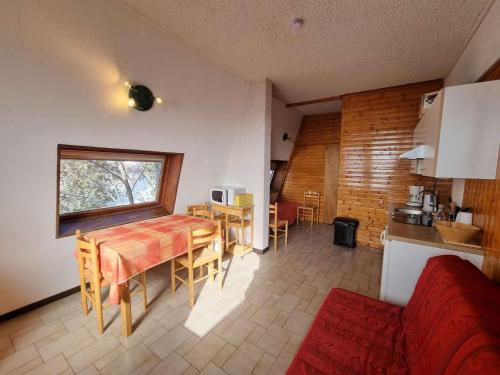 une cuisine et une salle à manger avec une table et une fenêtre dans l'établissement Appartement familial 5 pers avec terrasse Sud à Saint-Michel-de-Chaillol - FR-1-393-6, à Saint-Michel-de-Chaillol