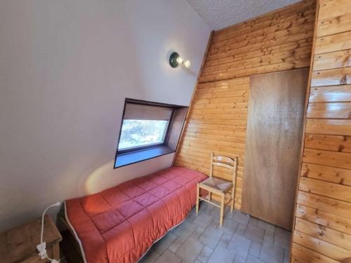 - une petite chambre avec un lit rouge et une fenêtre dans l'établissement Appartement familial 5 pers avec terrasse Sud à Saint-Michel-de-Chaillol - FR-1-393-6, à Saint-Michel-de-Chaillol