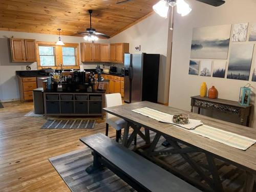 een keuken met een tafel en een keuken met een zwarte koelkast bij Wonderful cabin tucked in the woods /w Hot tub in Mountain City