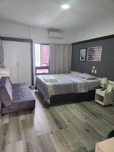 a bedroom with a bed and a bench in it at Tabajara flats in Fortaleza