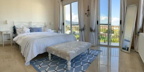 a white bedroom with a bed and a balcony at Casa Santos Kyrenia in Kérynia