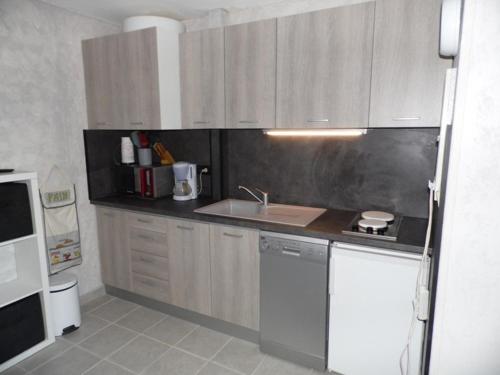 une cuisine avec un évier et un plan de travail dans l'établissement Appartement T2 cabine en RDC avec terrasse privative, parking et équipements confortables. - FR-1-326-383, à Marseillan