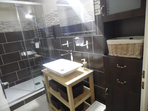 une salle de bain avec un lavabo et une douche dans l'établissement Appartement T2 cabine en RDC avec terrasse privative, parking et équipements confortables. - FR-1-326-383, à Marseillan