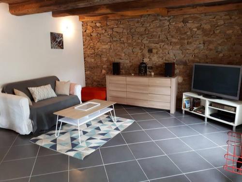 un salon avec un canapé et une télévision dans l'établissement Charmante Maison Proche de Dinan -Dinard - St Malo, à Pleslin-Trigavou