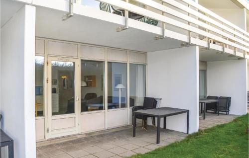 a patio with a table and a dining table at One-Bedroom Apartment In Ringkobing in Ringkøbing