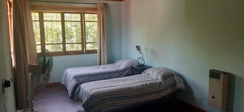 two twin beds in a room with a window at Casa Mármol 2085 MDZ Mendoza in Godoy Cruz
