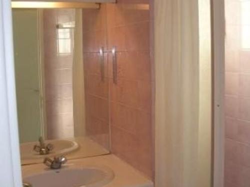 une salle de bain avec un lavabo et une douche avec un miroir dans l'établissement Charmant T2 avec Terrasse et Parking Privé, Proche Plage – Animaux Bienvenus! - FR-1-326-409, à Marseillan
