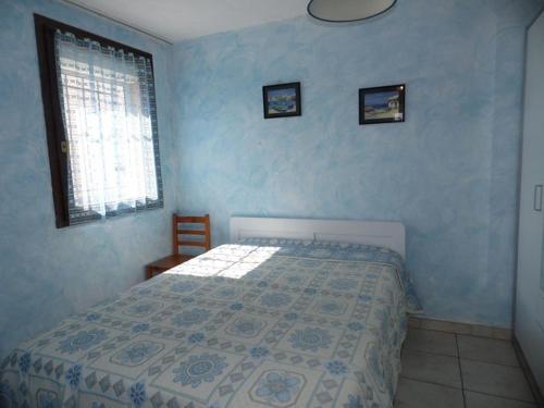 une chambre bleue avec un lit et une fenêtre dans l'établissement Charmant T2 avec Terrasse et Parking Privé, Proche Plage – Animaux Bienvenus! - FR-1-326-409, à Marseillan