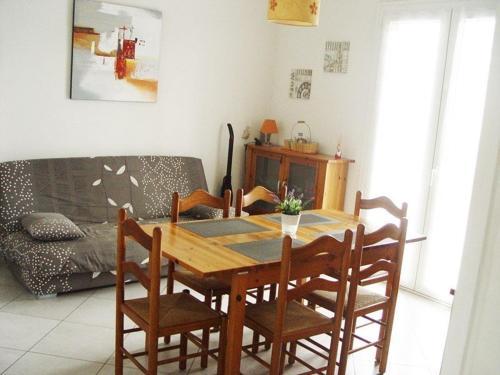 une table à manger et des chaises dans un salon dans l'établissement Appartement de 3 Pièces, 6-8 couchages, 2 terrasses, parking privé - Avenue de la Méditerranée - FR-1-326-479, à Marseillan