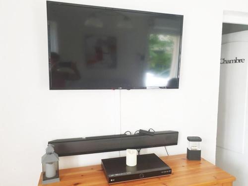 Elle comprend une télévision à écran plat sur la table en bois. dans l'établissement Appartement de 3 Pièces, 6-8 couchages, 2 terrasses, parking privé - Avenue de la Méditerranée - FR-1-326-479, à Marseillan