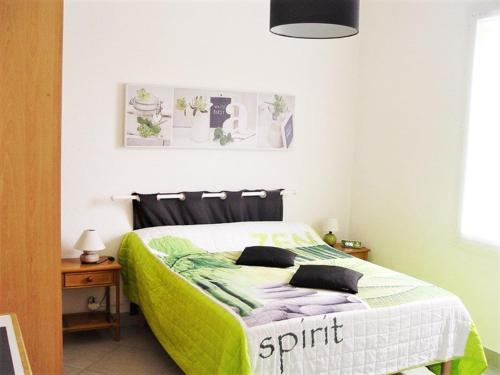 une chambre avec un lit avec une couverture verte dans l'établissement Appartement de 3 Pièces, 6-8 couchages, 2 terrasses, parking privé - Avenue de la Méditerranée - FR-1-326-479, à Marseillan