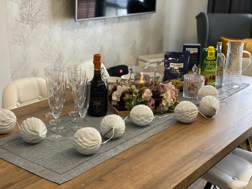 a table with a bottle of wine and wine glasses at Apartmány DOME in Doksy