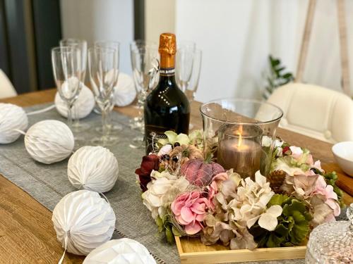 a table topped with a bottle of wine and flowers at Apartmány DOME in Doksy