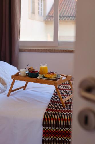 a tray of food on a table on a bed at House Prada in Bragança