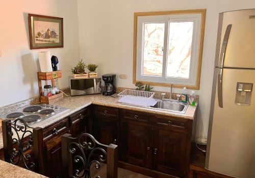 a kitchen with a sink and a stove and a window at Villas Gasconia in Antigua Guatemala
