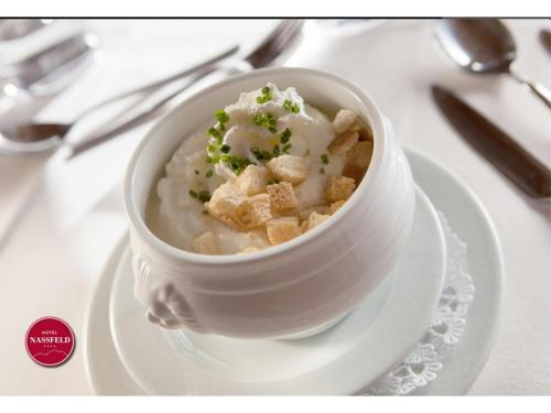 a bowl of food on a plate on a table at Hotel Nassfeld in Sonnenalpe Nassfeld