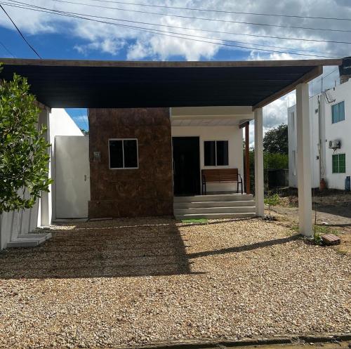 una pequeña casa blanca con techo negro en Habitación confortable y terraza Hamacas Coveñas, en Coveñas