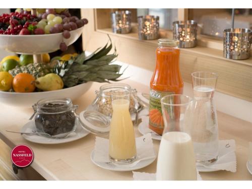 a kitchen counter with bottles of milk and a bowl of fruit at Hotel Nassfeld in Sonnenalpe Nassfeld