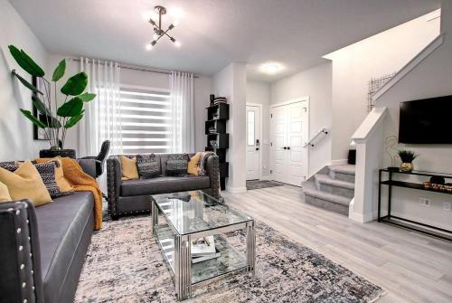 a living room with a couch and a tv at Beautiful 3Bed-with AC-Close to Spruce Meadows & Mountains in Calgary