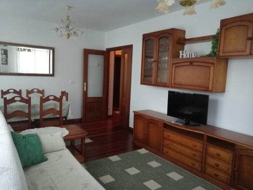 a living room with a couch and a tv at APARTAMENTO LA GRANJA EN GAMA(next to Santoña) in Gama