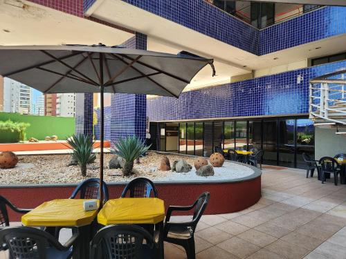 um pátio com um guarda-sol e uma fonte num edifício em Condomínio Porto de Iracema em Fortaleza