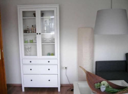 einen weißen Schrank im Wohnzimmer mit Sofa in der Unterkunft Haus Ellbogen in Momlingen