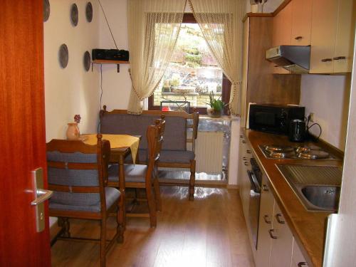 a kitchen with a table and chairs and a window at Haus Ellbogen in Momlingen