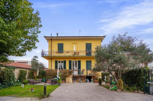 une maison jaune avec un balcon au-dessus dans l'établissement Villa San Donato B&B, à Lucques