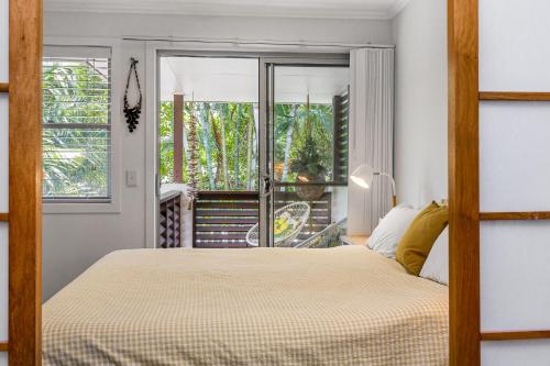 a bedroom with a bed and a balcony at Browning Street Sea Drift in Byron Bay