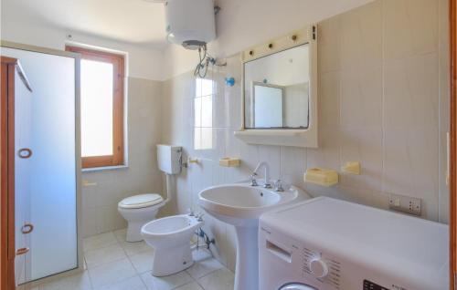y baño con lavabo, aseo y espejo. en Pet Friendly Apartment In San Leonardo Di Cutro With Kitchen, en Le Castella