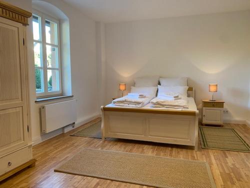 1 dormitorio con 1 cama con 2 lámparas y una ventana en Charmantes Gästehaus Maya im Schloß und Hofgut Langenzell, en Wiesenbach