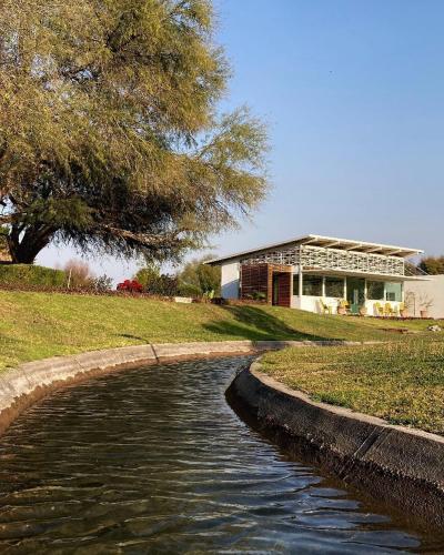 a waterway in front of a house and a building at Hotel Los Lirios in Jabalí