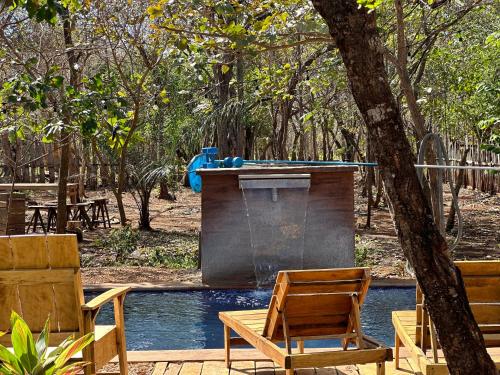 a pool with chairs and a table and a fountain at Finca Avellanas in Playa Avellana