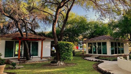 a small house with a tree in a yard at Hotel Los Lirios in Jabalí