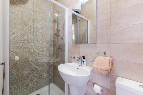 ein Bad mit einem Waschbecken und einer Glasdusche in der Unterkunft Spacious Brand New Apartment Huge Terrace 3 Bdr 2 Bth Bugibba in St Paul's Bay