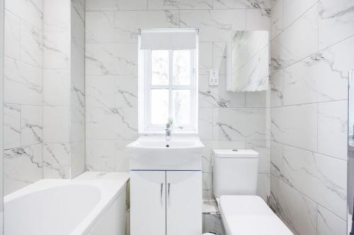 a white bathroom with a sink and a toilet at Ofrise Homes in Barking