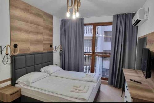 a bedroom with two beds and a large window at Deluxe Appartement in Cascadas Resort Sunny Beach in Sunny Beach