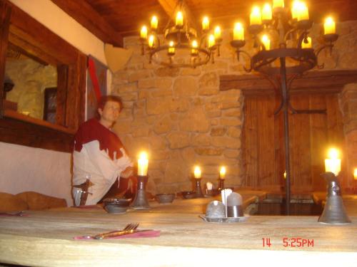 a man standing next to a table with lit candles at Penzion Hrad in Frýdek-Místek