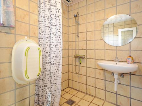 een badkamer met een wastafel en een spiegel bij Holiday Home Hedevang V in Oksbøl