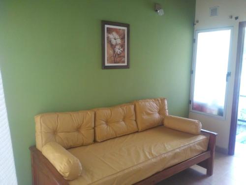 un sofá en una sala de estar con una pared verde en Las dos A en Chascomús