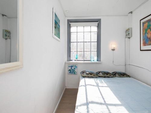 1 dormitorio con 1 cama en una habitación con ventana en Holiday home Hjørring XXXII, en Hjørring