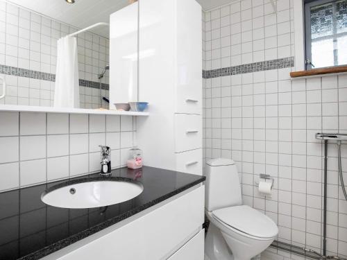 Baño blanco con lavabo y aseo en Holiday home Hjørring XXXII, en Hjørring