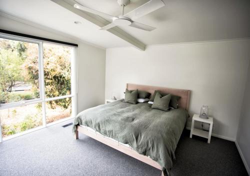 a white bedroom with a bed and a ceiling fan at LONSDALE ON GLANEUSE in Point Lonsdale